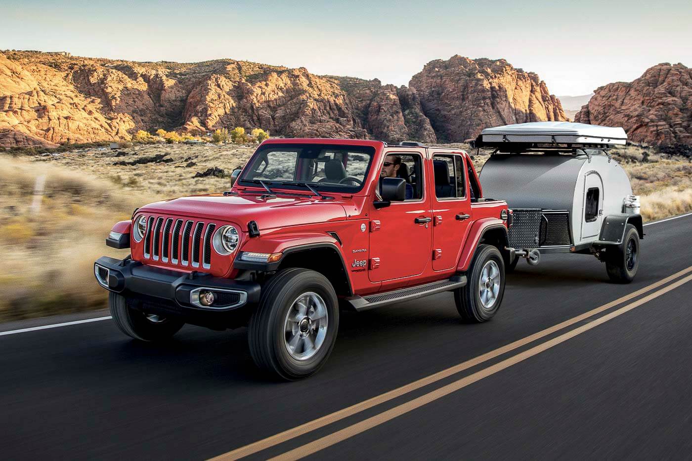 vue trois quart avant du Jeep Wrangler Unlimited Sahara 2022 remorquant une tente-roulotte