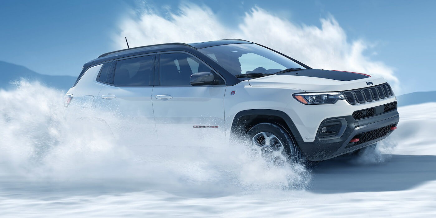 vue latérale du Jeep Compass Trailhawk 2022 roulant dans la neige
