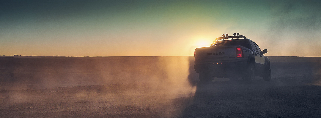 Vue arrière du RAM 1500 2022 devant un couché de soleil à travers la poussière