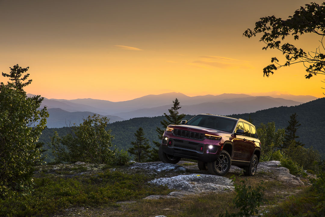vue latérale avant d'un Jeep Grand Cherokee 2022 en montagne au crépuscule