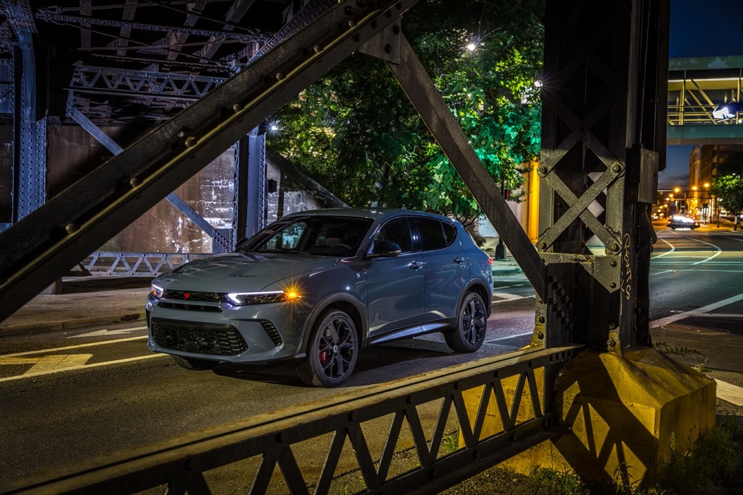 Le Dodge Hornet 2023 avec ses phares allumés, garé au-dessous d'un viaduc.