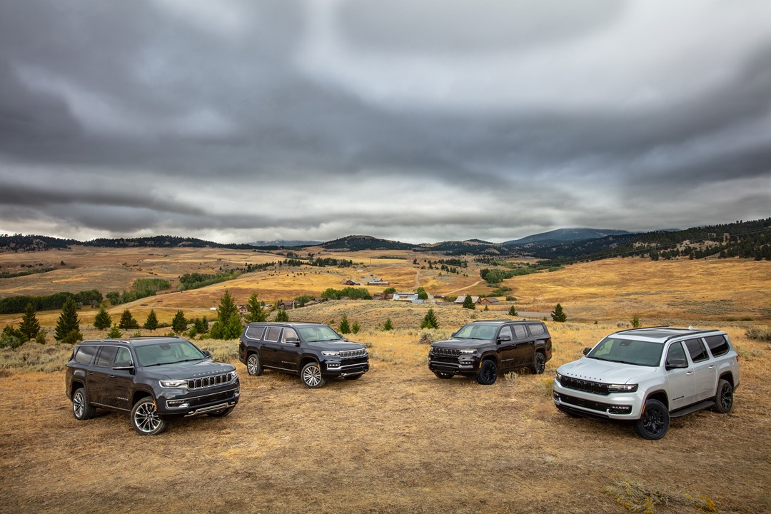 vue d'une gamme de véhicules Wagoneer devant un paysage de campagne