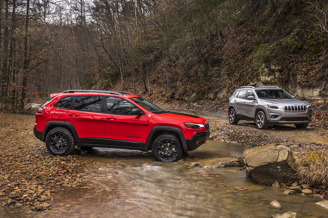 Vue d'un Jeep Cherokee Trailhawk et Jeep Cherokee Limited en route de campagne