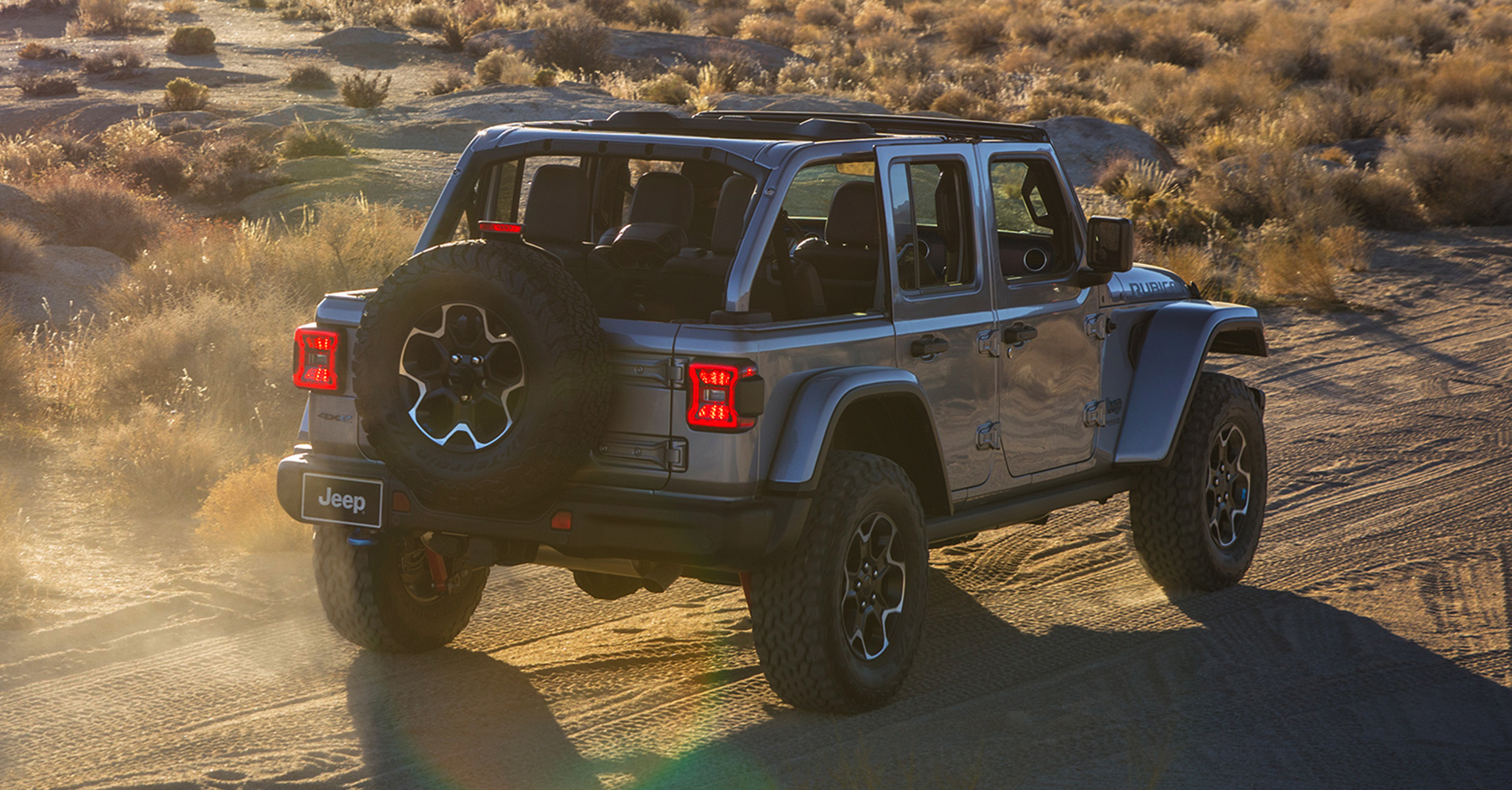 vue arrière du Jeep Wrangler Rubicon 4xe 2021 gris métallisé conduisant dans un désert