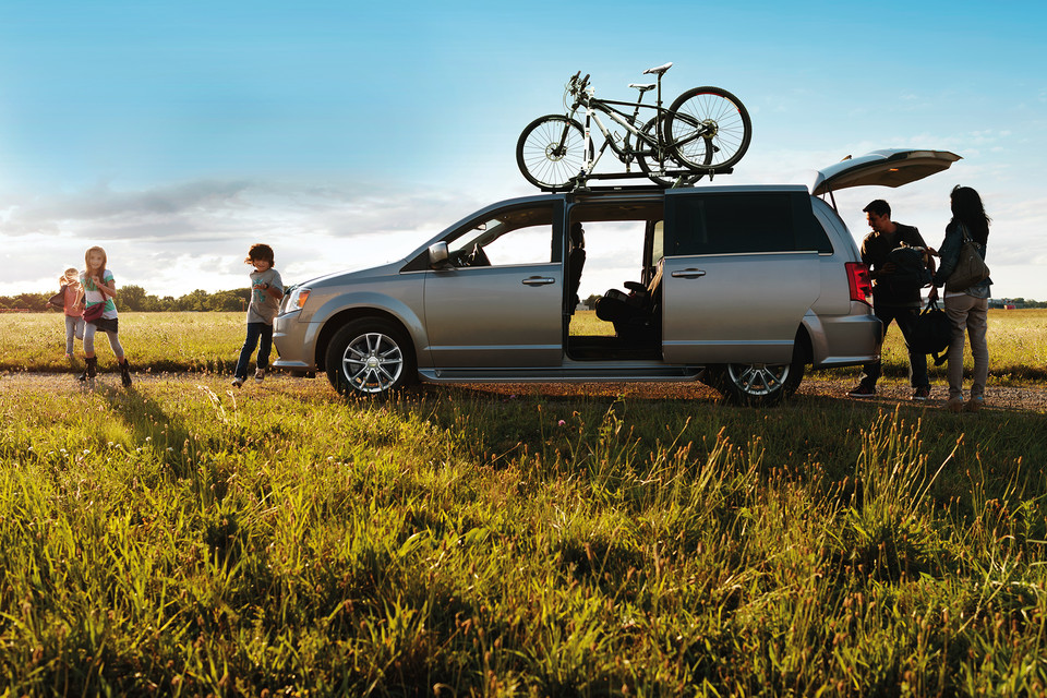 Le DODGE GRAND CARAVAN 2020 entouré d'une famille en plein air