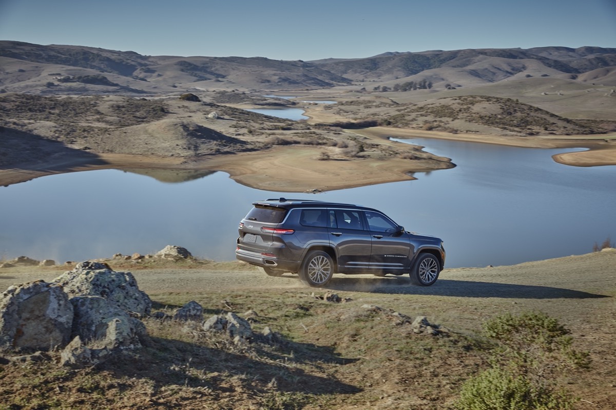 Vue 3/4 latérale du Jeep Grand Cherokee L Summit Reserve 2021 roulant sur un chemin en nature