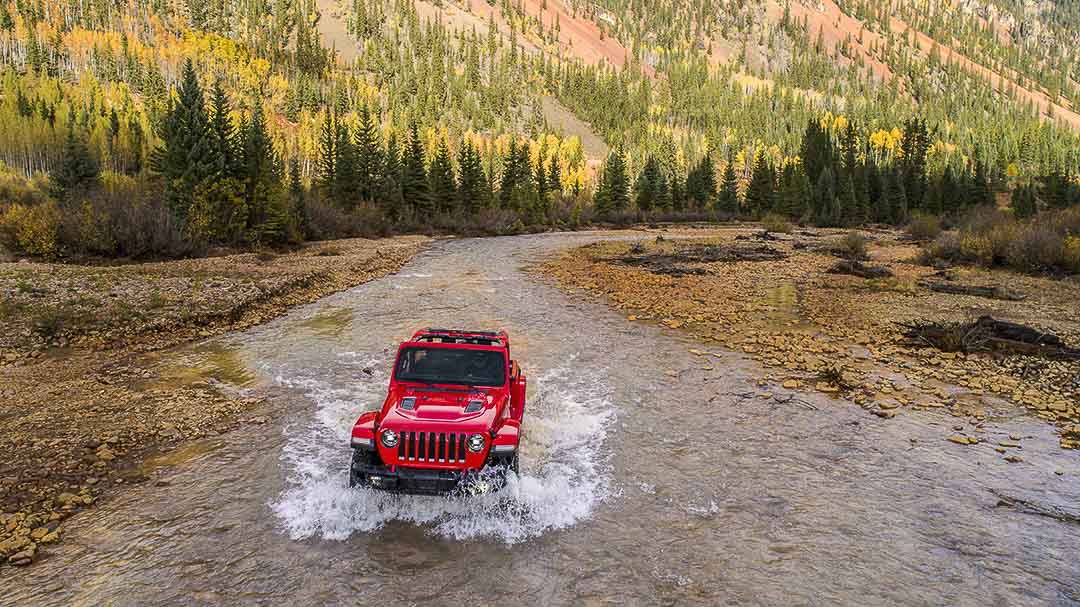 vue en plongée donnant sur l'avant du Jeep Wrangler 2021 roulant dans un ruisseau