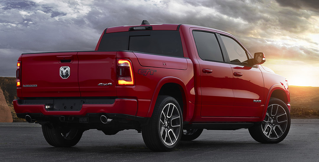 Vue 3/4 arrière du RAM 1500 Laramie G/T 2022 rouge sous le ciel éclaici